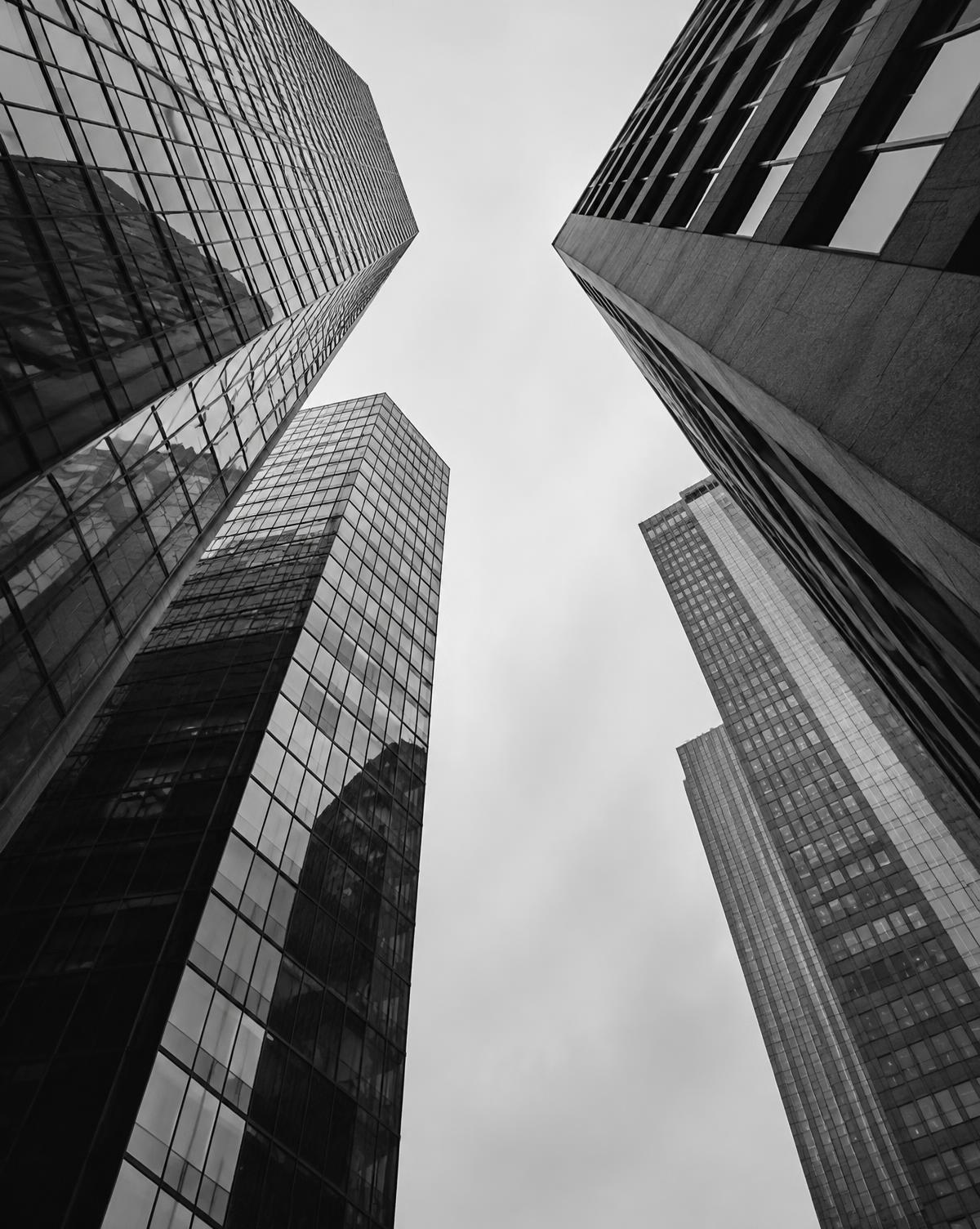 Looking up between glass and concrete office towers